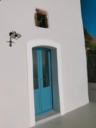 a blue door on the side of a white wall at L'Olivuzza in Alicudi