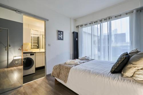 une chambre avec un grand lit et un miroir dans l'établissement L'ADREÏA Confortable T2 - Rénové - Lumineux - Calme - Parking - proche Lille & Tramway, à Marcq-en-Barœul