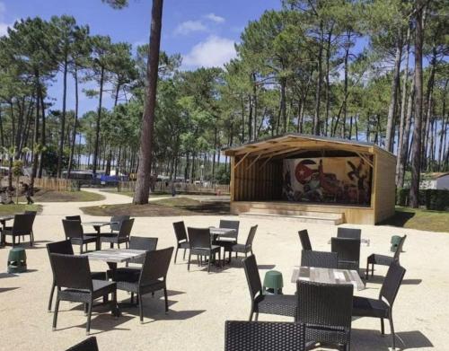 - un coin salon avec des tables et des chaises dans un parc dans l'établissement La Lette fleurie - Mobil home Spacieux climatisé 6-8 personnes tout équipé en camping 4 étoiles, à Saint-Julien-en-Born