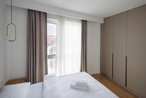 a bedroom with a white bed and a window at Moldovei 2 Apartments by Central Park in Cluj-Napoca