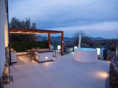 a patio with a hot tub and a grill at Villa Grazia 49 in Solicchiata