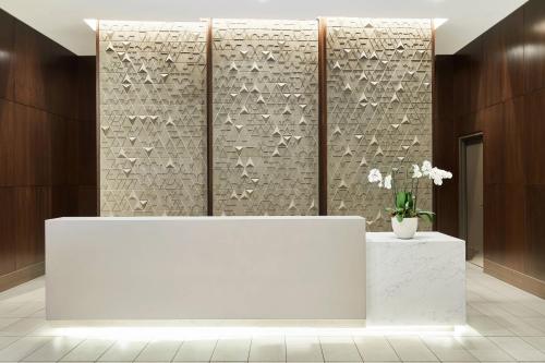 a lobby with a white counter and a wall at AC Hotel by Marriott Beverly Hills in Los Angeles