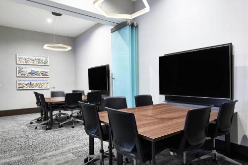 a conference room with a table and chairs and a large screen at AC Hotel by Marriott Beverly Hills in Los Angeles
