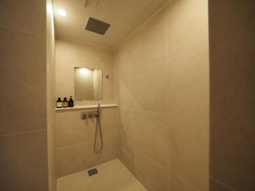 a bathroom with a shower and a mirror at Daisy hotel in Tongyeong