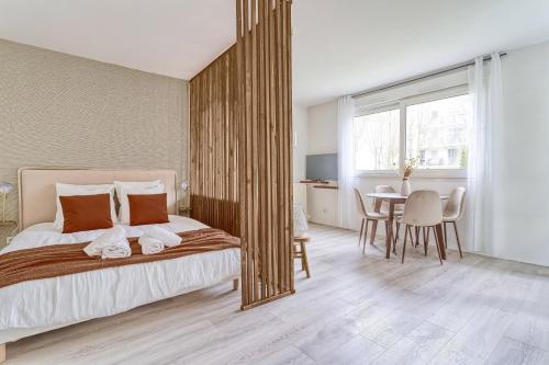 une chambre avec un lit et une table avec des chaises dans l'établissement Appartement 10min de Disney- 2min RER A-30min Paris - Parking gratuit, à Bussy-Saint-Georges