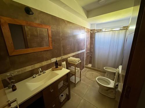 un baño con inodoro y lavabo en IL Ocaso Apart, en San Rafael