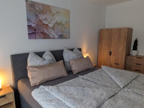 a bedroom with a bed with pillows and a painting at Ferienwohnung Zur Coleus-Farm in Colditz