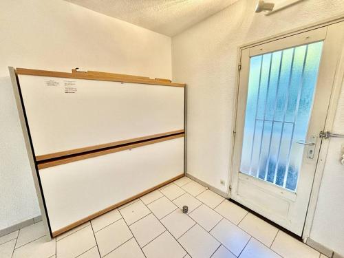 Cette chambre dispose d'une fenêtre et d'un réfrigérateur blanc. dans l'établissement Appartement confortable avec terrasse, proche plages - FR-1-816-1, au Lavandou