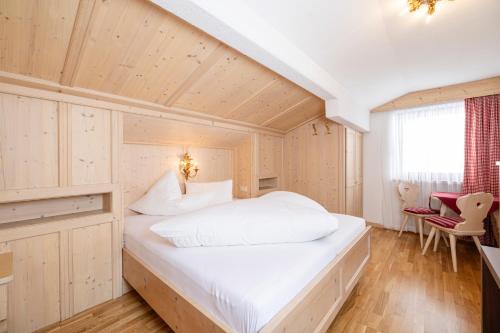 a bedroom with a large white bed in a room at Aparthotel Landhaus St. Joseph (Indoor Pool) in Mayrhofen