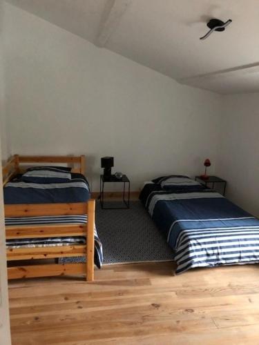 une chambre avec deux lits et un ventilateur de plafond dans l'établissement campagne chaleureuse, à Béruges