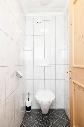 a white bathroom with a toilet in it at Aparthotel Landhaus St. Joseph (Indoor Pool) in Mayrhofen