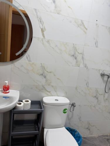a bathroom with a toilet and a sink and a mirror at Playa Surf House in Tamraght Ouzdar