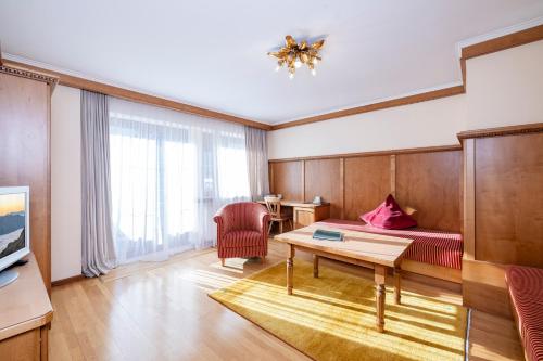 a living room with a bed and a table at Aparthotel Landhaus St. Joseph (Indoor Pool) in Mayrhofen