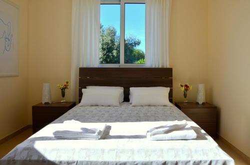 - une chambre avec un lit et 2 serviettes dans l'établissement Domino Blue Apartment, à Paralímni
