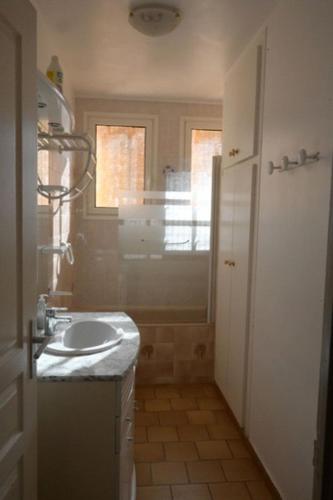 une petite salle de bain avec un lavabo et une fenêtre dans l'établissement La Maison du Vigneron, à Montpeyroux