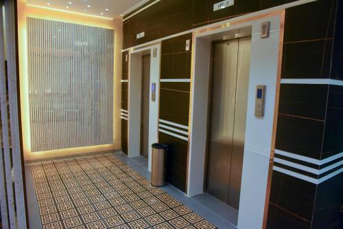 a hallway with two elevators and a tile floor at Dasara Executive in Tuljapur