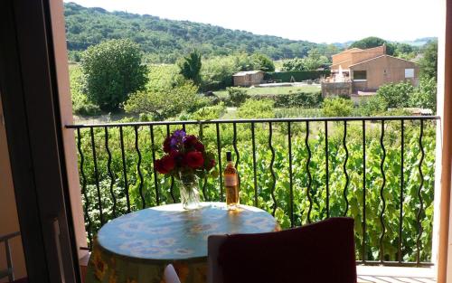 une table avec un vase de fleurs sur un balcon dans l'établissement Gite olivier a gassin, à Gassin