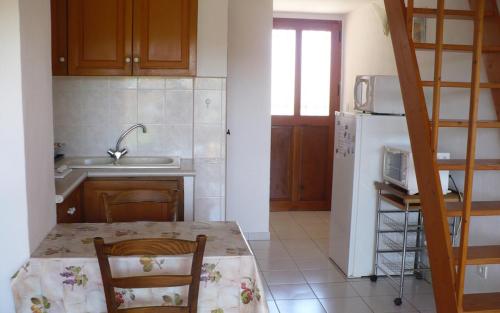 une cuisine avec une table et un réfrigérateur blanc dans l'établissement Gite olivier a gassin, à Gassin