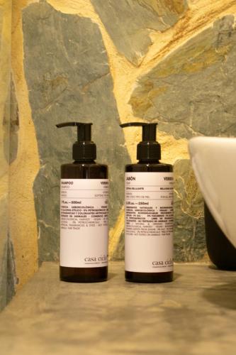 two bottles ofodorizers sitting on a counter next to a sink at Casa Zoé Hotel Boutique in Villeta