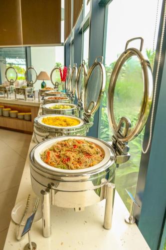 a row of trays of pizzas in a kitchen at Arena Cam Ranh Pearl Bay in Cam Ranh