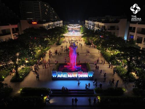a group of people walking around a fountain at night at Arena Cam Ranh Pearl Bay in Cam Ranh