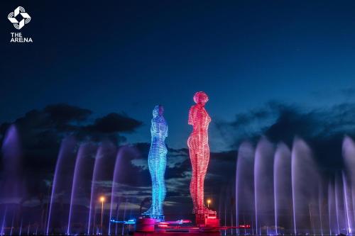 two lit up figures standing in front of a fountain at Arena Cam Ranh Pearl Bay in Cam Ranh