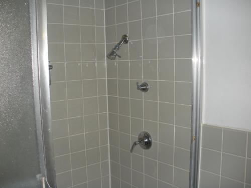 y baño con ducha con cabezal de ducha. en Kings Inn Cleveland, en Strongsville