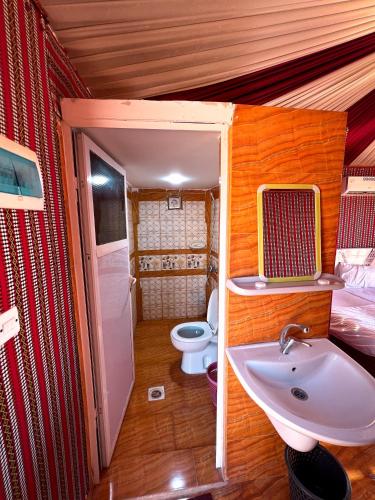 a bathroom with a sink and a toilet in a room at Natalie Wadi Rum camp & Jeep tour in Wadi Rum