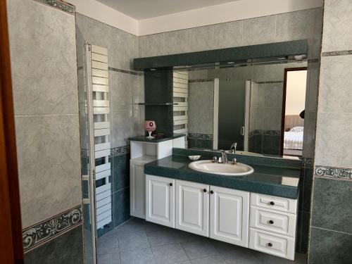 une salle de bain avec un lavabo et un miroir dans l'établissement la Villa Bella Vista, à Agde