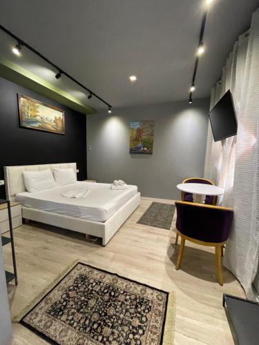 a bedroom with a white bed and a table at Destination Central Room 2 in Tirana