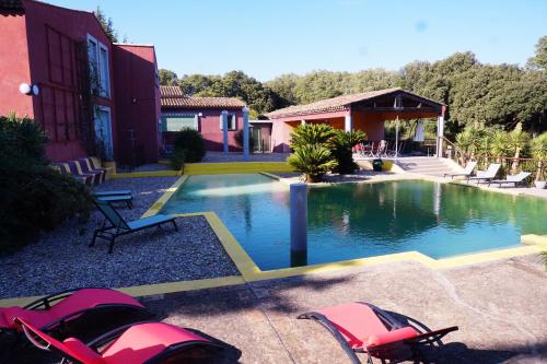 - une piscine en face d'un bâtiment avec une maison dans l'établissement Villa - Domaine à GRANS grande demeure 6 à 12pers, à Grans