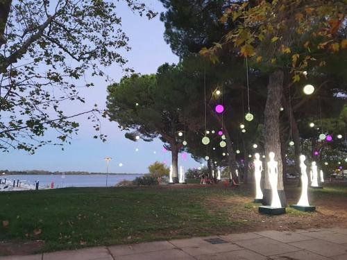 un parc avec un groupe de statues blanches dans l'herbe dans l'établissement Joli studio au Ponant avec parking, à La Grande Motte