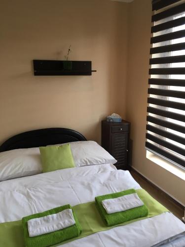 a bedroom with a bed with green and white towels on it at Abszolút Hotel és Panzió in Nyírbátor