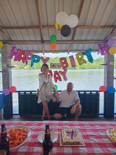 a man and a woman sitting in front of a table with a cake at Lake Lane Guest Rest in Koggala