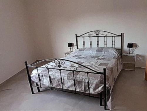 un letto in una camera da letto con due lampade e due tavoli di Casa Vacanze Caterina a Matino