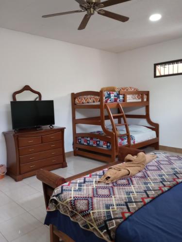 a bedroom with a bed and a dresser with a tv at Casa Niño Peregrino Salinas in Salinas