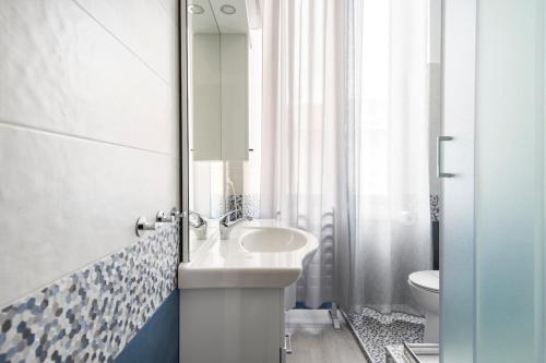 a bathroom with a sink and a toilet and a mirror at Leo Holiday Homes in Deiva Marina
