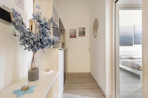a room with a vase with blue flowers on a table at Leo Holiday Homes in Deiva Marina