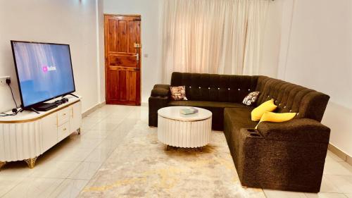a living room with a couch and a flat screen tv at Cozy & Spacious 2 Bed Apt in Malindi in Malindi