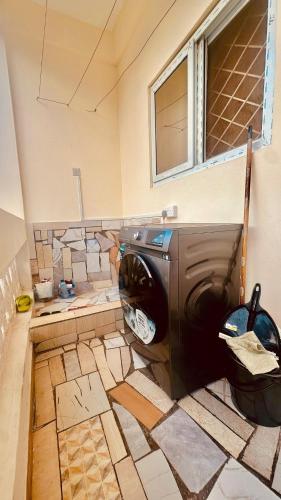 a washer and dryer in a room with a wall at Cozy & Spacious 2 Bed Apt in Malindi in Malindi