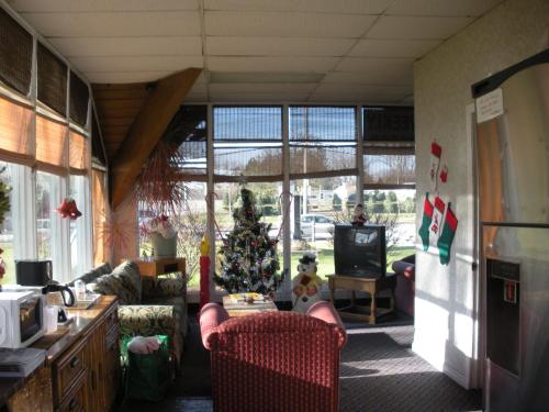 Una sala de estar con un árbol de Navidad en la esquina. en Kings Inn Cleveland, en Strongsville