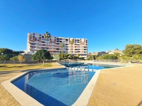 a large swimming pool with a building in the background at CALARREONA - Apartamento a 100 metros de la playa in Águilas