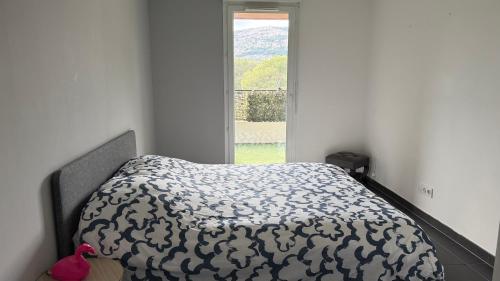 un lit dans une chambre blanche avec une fenêtre dans l'établissement T2 proche calanque sormiou, à Marseille