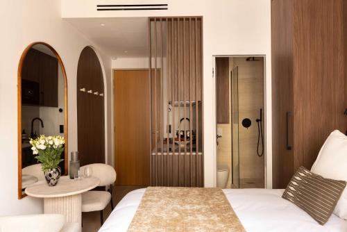 - une chambre avec un lit et une table ainsi qu'une salle de bains dans l'établissement Charming Studio climatisé - 2P- Madeleine, à Paris