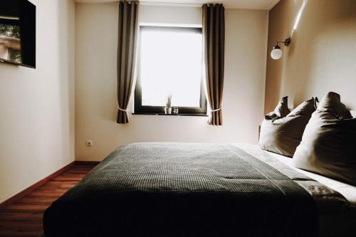 a bedroom with a large bed with a window at Ferienwohnungen am Scharmützelsee in Diensdorf-Radlow