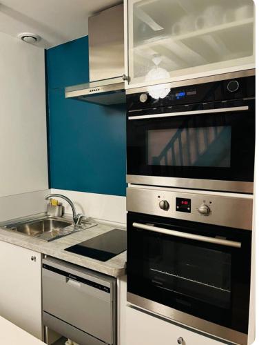 a kitchen with a stove and a sink at Le duplex in Compiègne