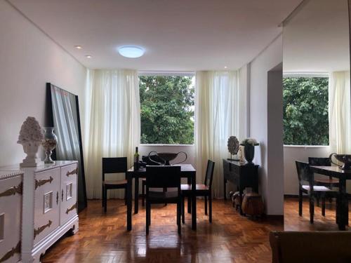 a dining room with a table and chairs and windows at Apartment in Ondina, Carnival Circuit, Luxury in Salvador