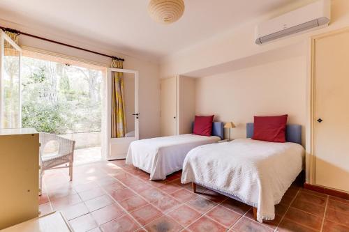 deux lits dans une chambre avec une fenêtre dans l'établissement Villa provençale face à la mer, à Sainte-Maxime