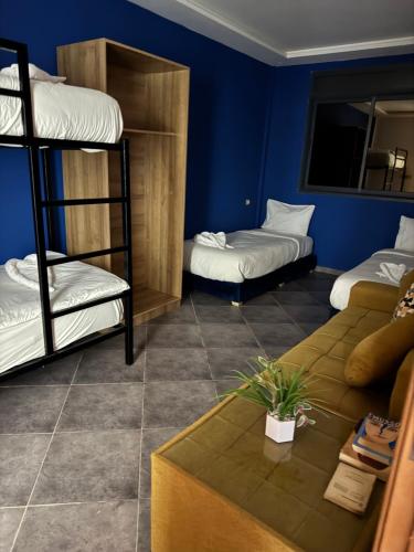 a room with two bunk beds and a couch at Playa Surf House in Tamraght Ouzdar