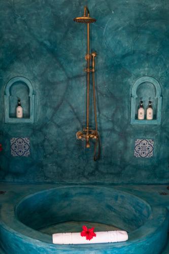 a blue bathroom with a tub with a shower at Casa Paradis Boutique Hotel in Jambiani